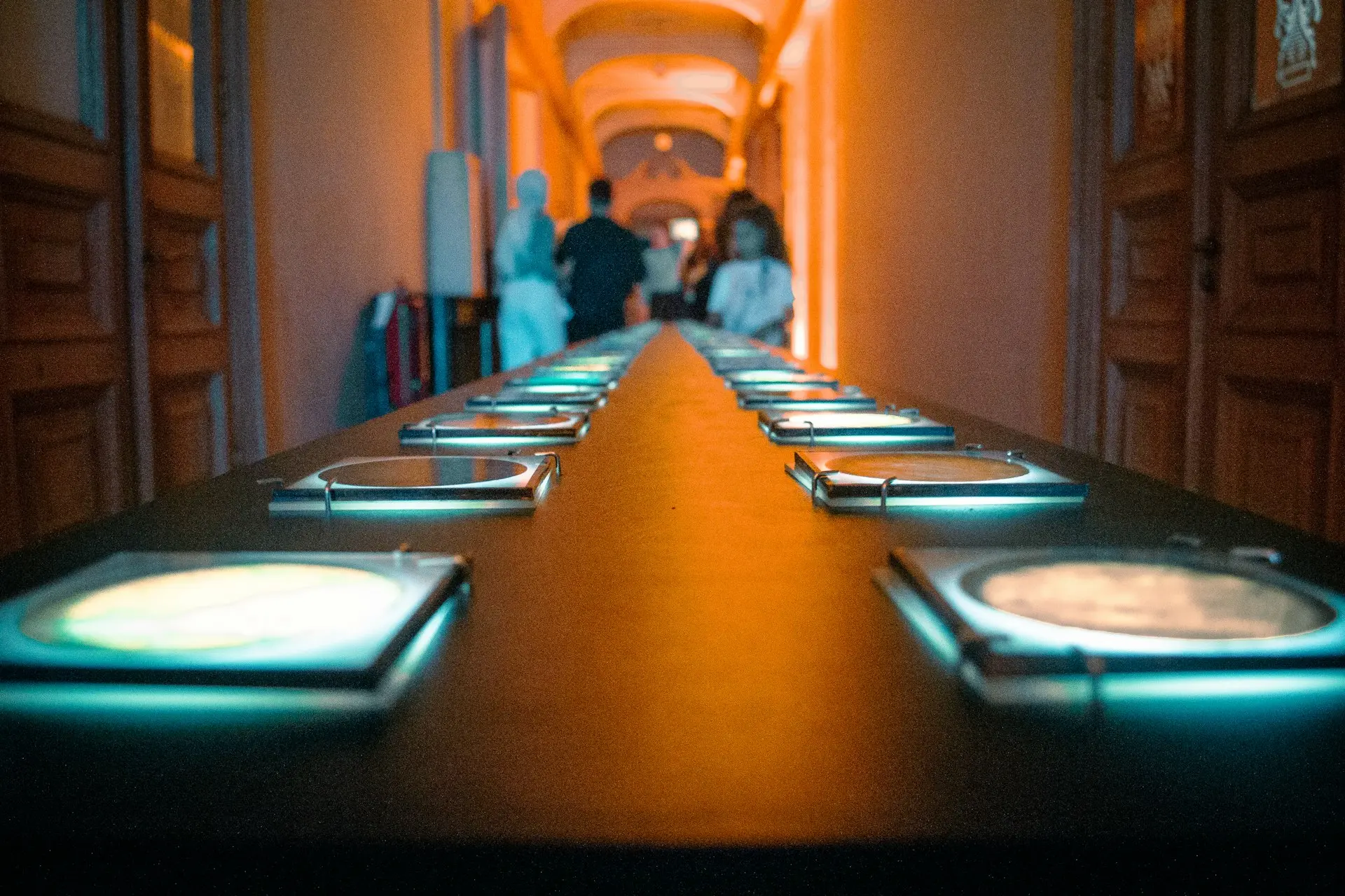 A long table displays numerous illuminated screens.